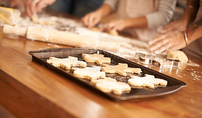 Buy stock photo Bake, gingerbread man biscuits and people in kitchen of home, closeup for cooking or pastry preparation. Food, baking or cookies with hands of family at wooden counter in apartment for snack recipe 