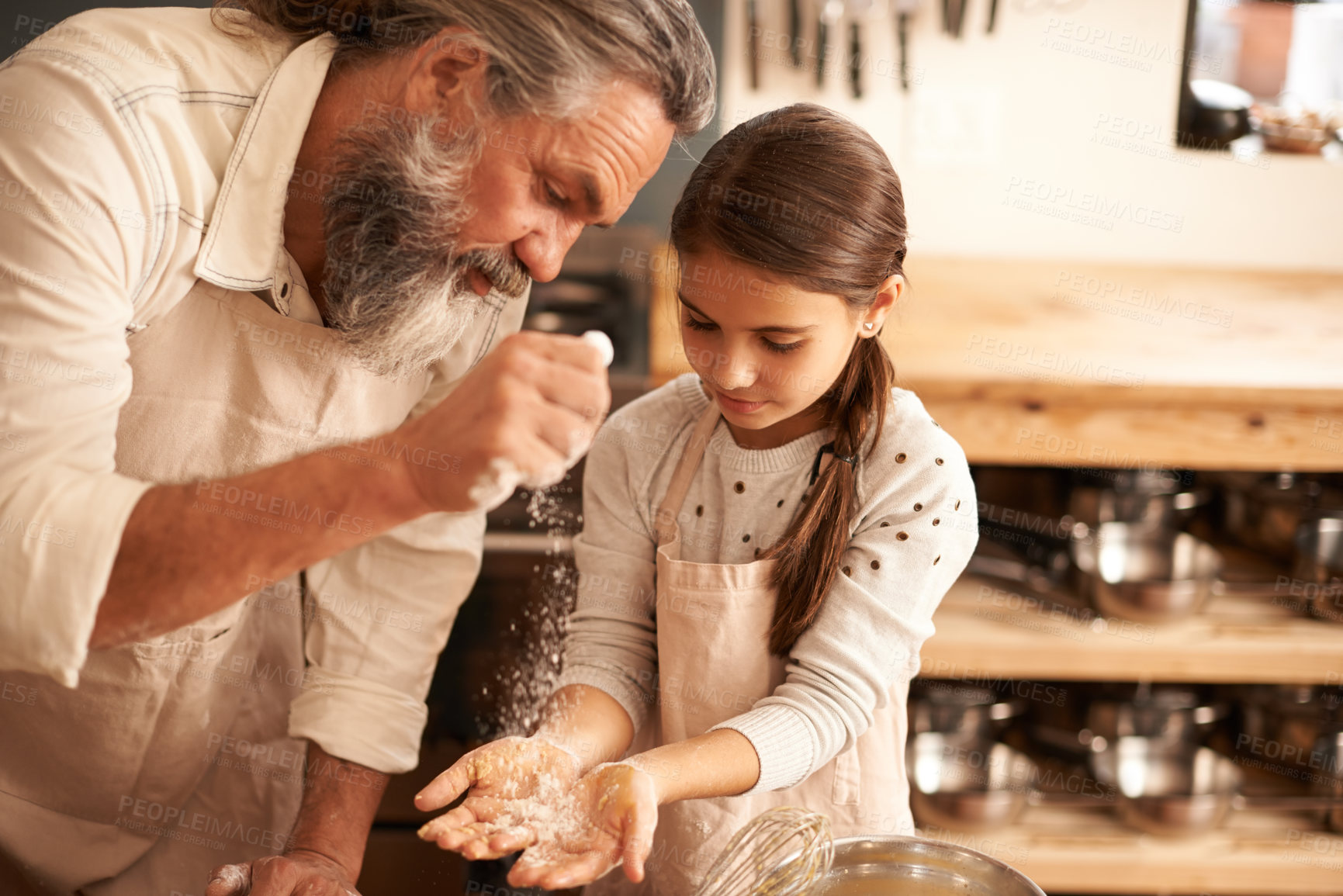 Buy stock photo Shot of a girl bonding with her grandfather as they bake in the kitchen