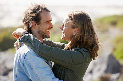 Buy stock photo Shot of an affectionate young couple standing face to face in the outdoors
