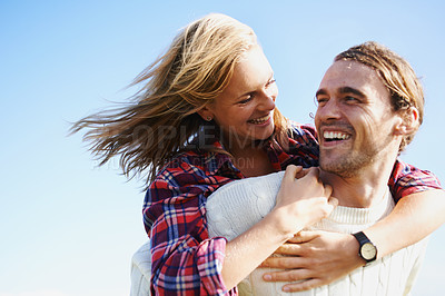 Buy stock photo Happy couple, travel and bonding together in nature, piggyback and romantic getaway on holiday by blue sky. Man, woman and love on vacation on weekend break, joy and adventure in outdoor on honeymoon