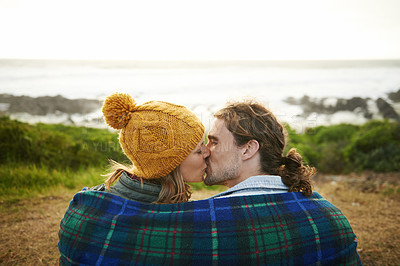 Buy stock photo Happy couple, kiss and bonding together in nature, blanket and romantic getaway with camping by ocean. Man, woman or love on vacation on weekend break, cape town or travel adventure by sea in sunset