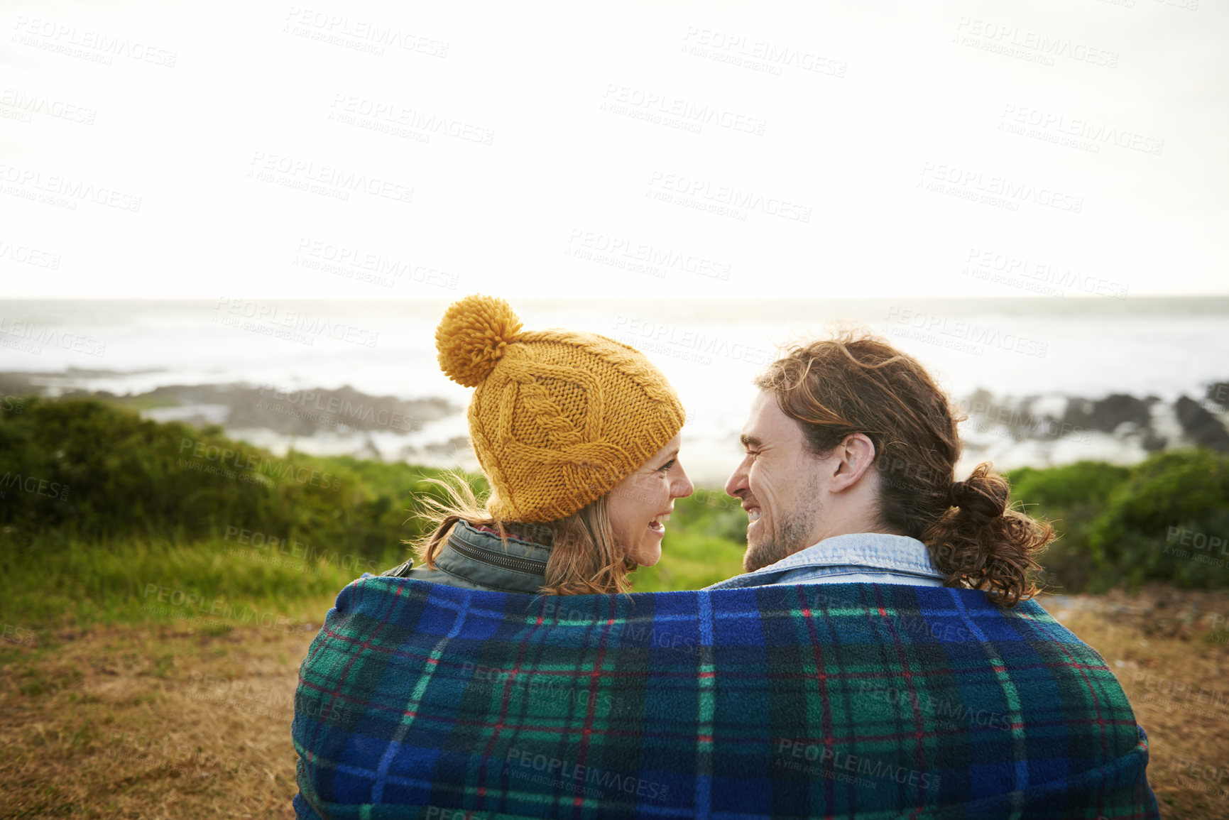 Buy stock photo Happy couple, talking or bonding together in nature, blanket or romantic getaway with camping by ocean. Man, woman or love on vacation on weekend break, cape town or travel adventure by sea in sunset