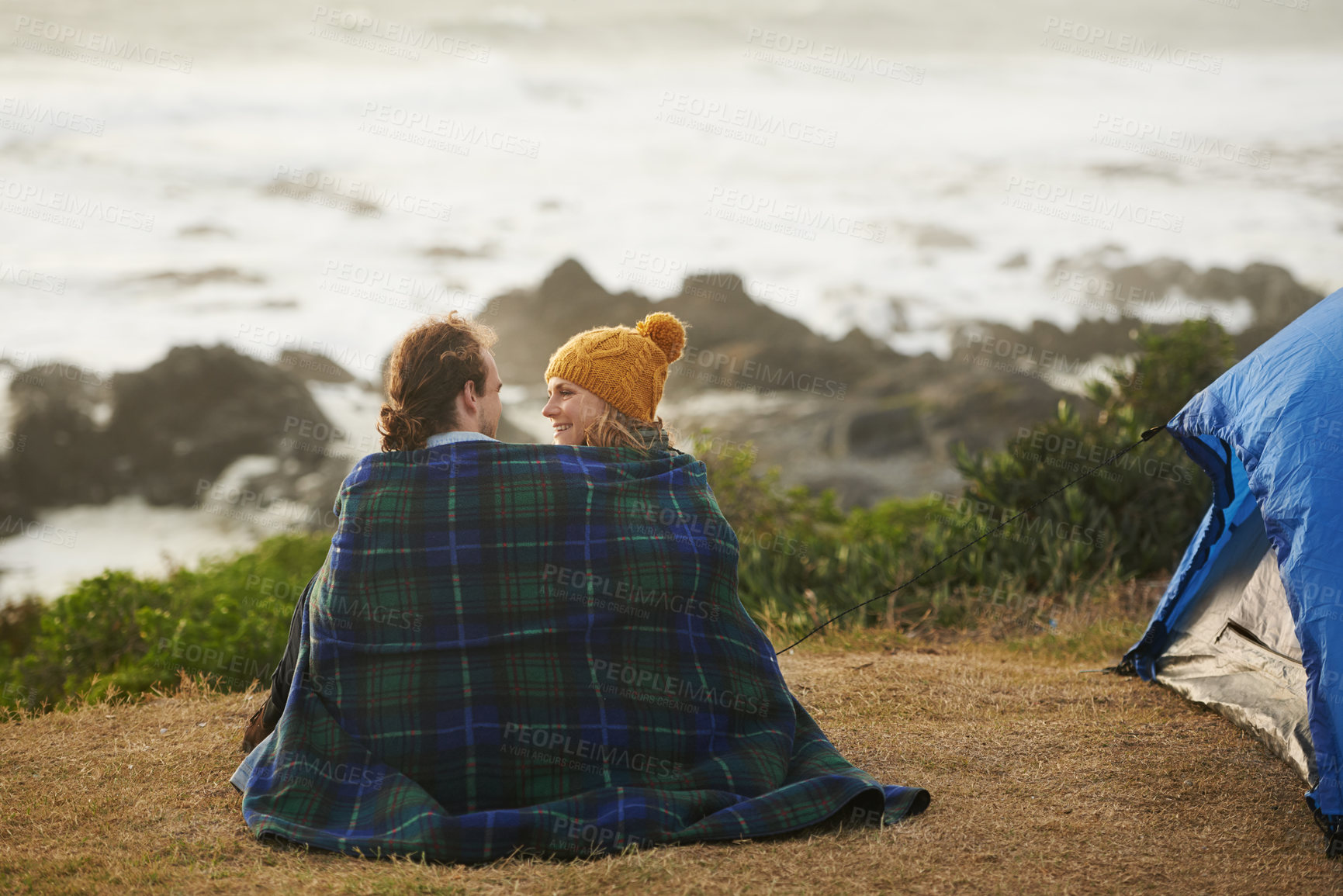 Buy stock photo Couple, blanket and back view at camp, beach and travel with bonding for date or anniversary. Love, trust and commitment with partner, loyalty and cuddle for warmth in winter with camping in nature