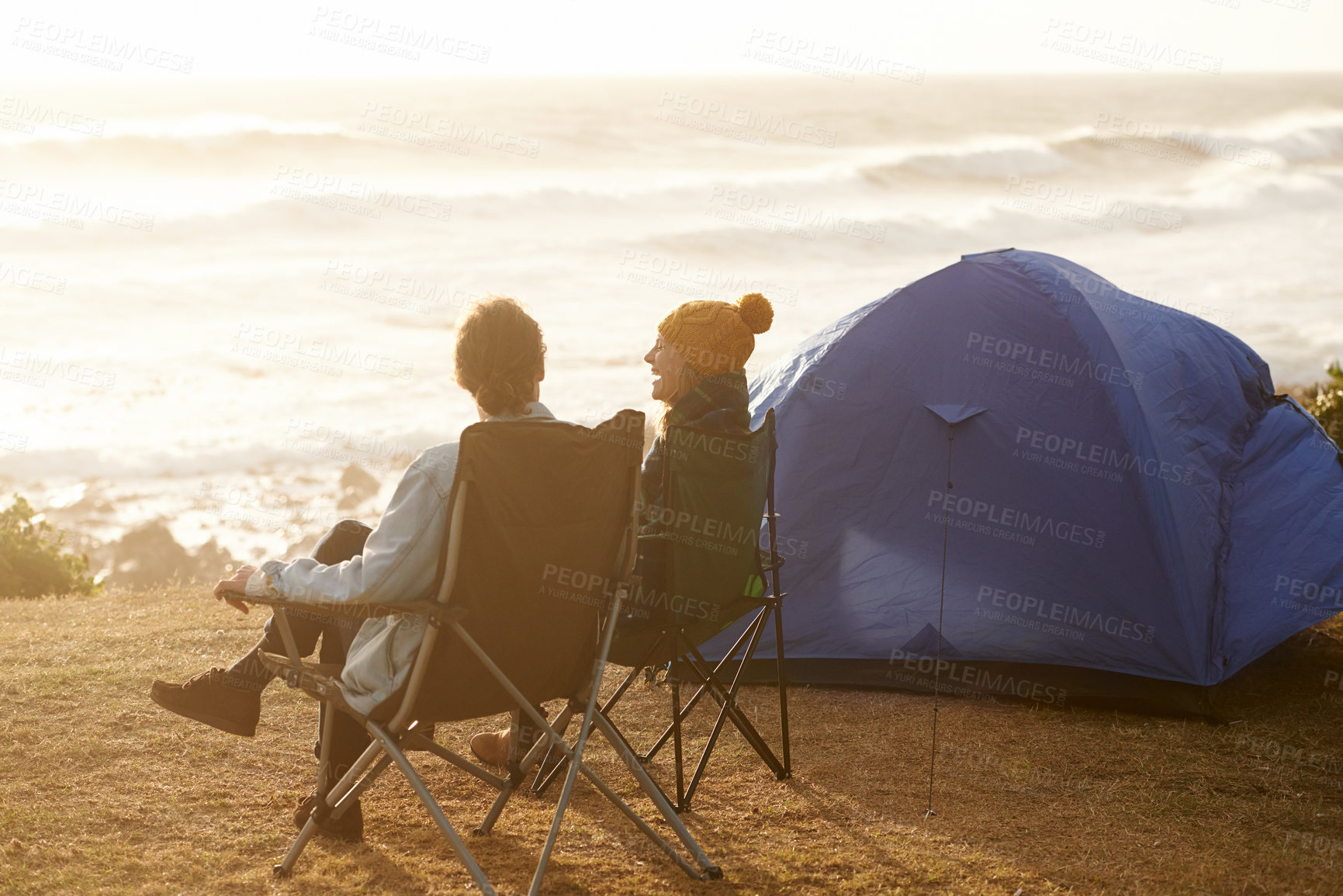 Buy stock photo Cropped shot of a young couple sitting at their campsite