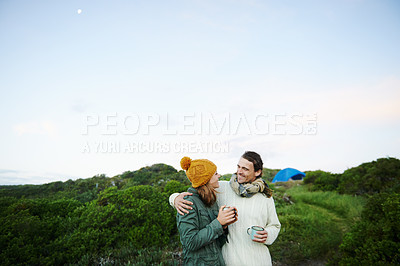 Buy stock photo Cropped shot of an affectionate young couple standing outdoors with drinks