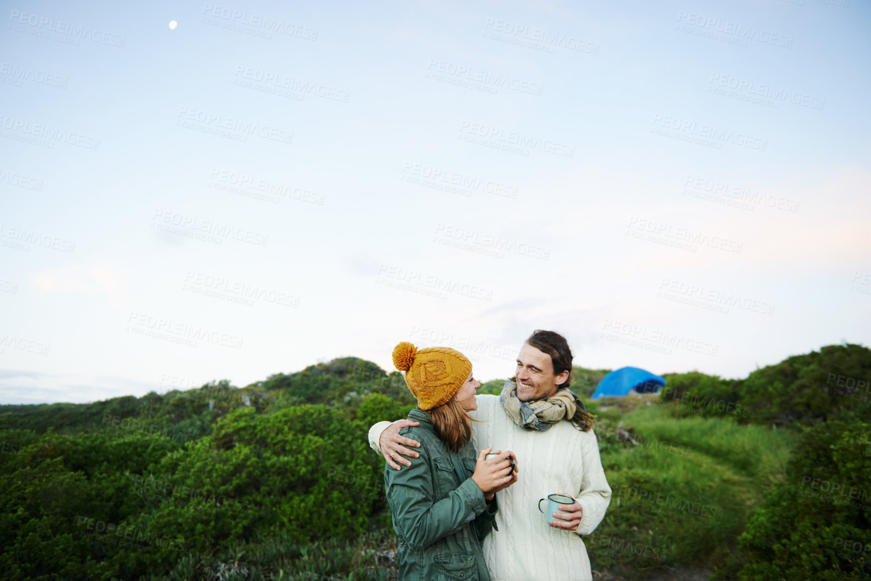 Buy stock photo Cropped shot of an affectionate young couple standing outdoors with drinks