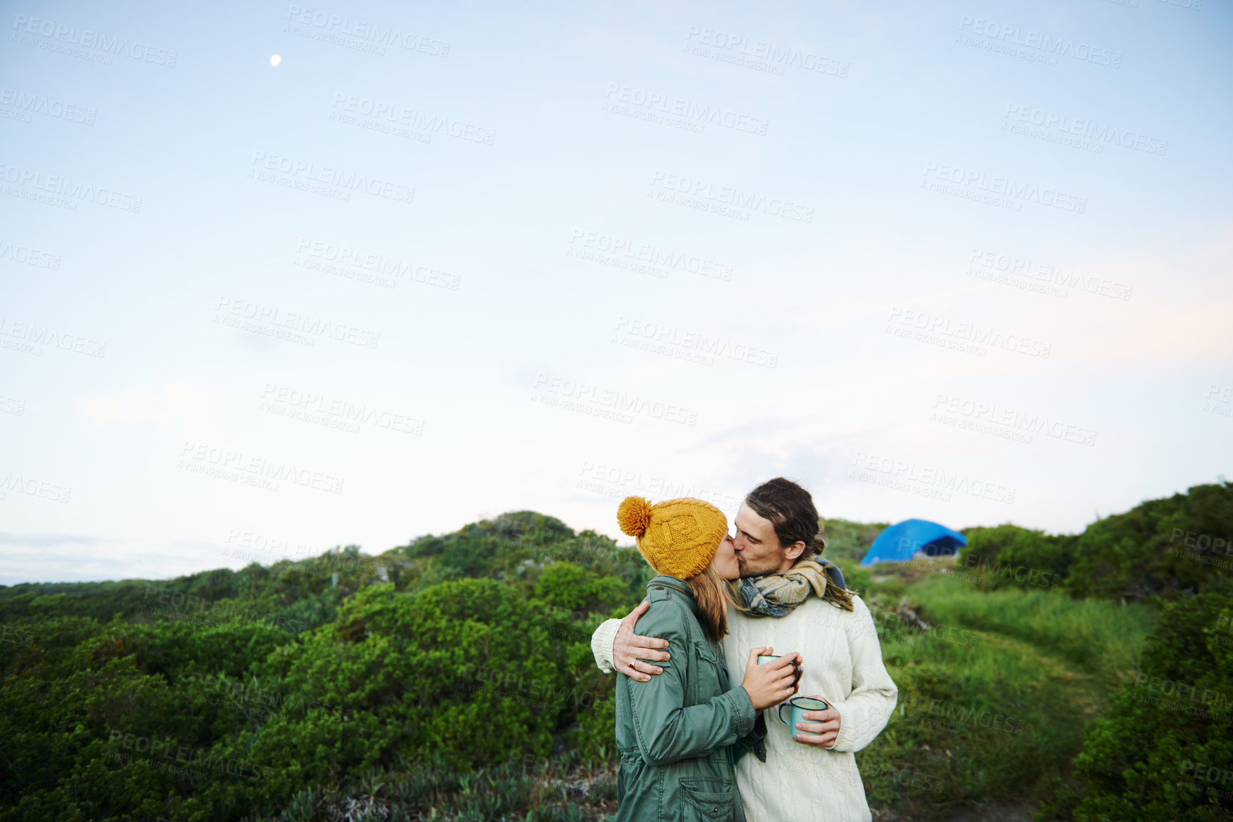 Buy stock photo Camping, nature and couple with love, kiss and smile with happiness and holiday for honeymoon. Romance, travel or man with woman or embrace with vacation or bonding together with adventure or journey