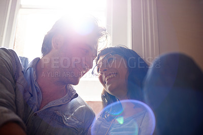 Buy stock photo Lens flare, relax or happy couple laughing in home living room in conversation and speaking together. Man, funny woman or romantic people in apartment or house talking with love, low angle or joke