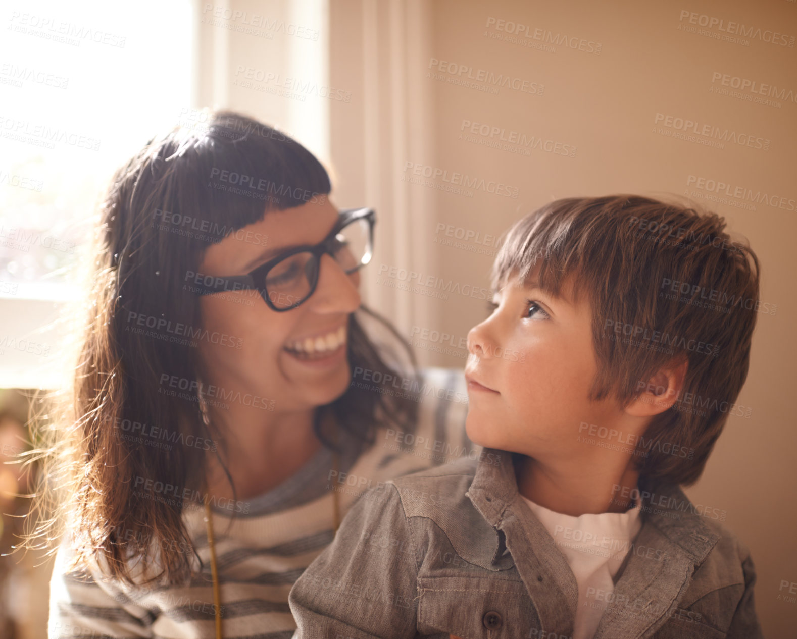 Buy stock photo Love, mother and son bonding, happiness and conversation at home, funny and laughing. Family, female parent and happy mama with a male child, boy and kid with joy, loving and relax in a living room