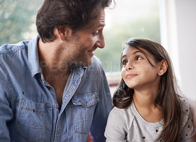 Buy stock photo Shot of a father and daughter sitting on their living room sofa