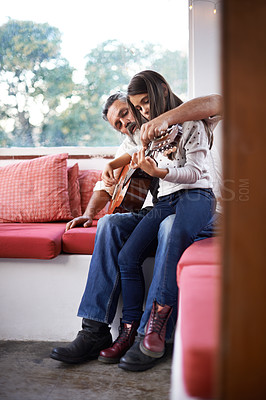 Buy stock photo Cropped shot of a little girl playing guitar with her grandfather