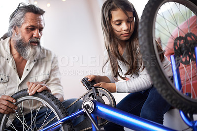Buy stock photo Father, child and bicycle for fixing chain as maintenance in garage for bonding together, transportation or teamwork. Mature man, daughter and equipment for bike repair or gear help, wheel or tyre