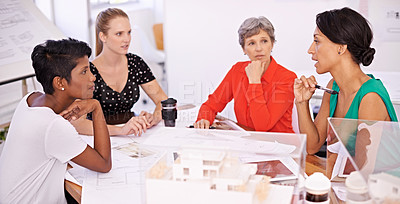 Buy stock photo A group of female architects working together on a project at a conference table