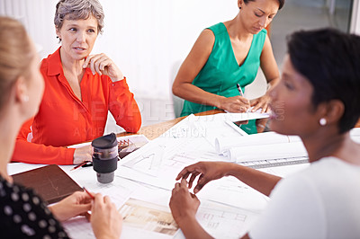 Buy stock photo A group of female architects working together on a project at a conference table