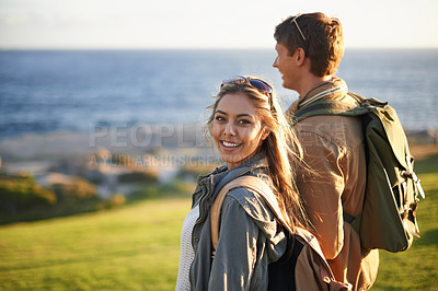 Buy stock photo Portrait of a young couple standing on the edge of an embankment overlooking the ocean