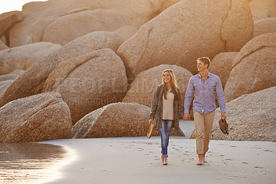 Buy stock photo Love, ocean and happy couple on walk holding hands, sunset and tropical holiday adventure for bonding together. Rocks, man and woman on romantic date with beach, nature and relax on travel vacation