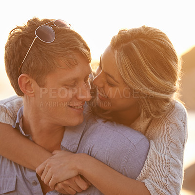 Buy stock photo Couple, sunset and hug for love by water, ocean waves and peace for romance in relationship. Happy people, looking and security in marriage, embrace and travel on vacation or holiday for outdoor date