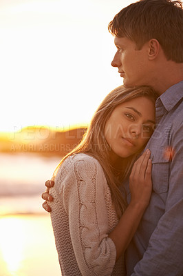 Buy stock photo Couple, portrait and hug by beach at sunset, ocean waves and peace for romance in relationship. People, commitment and security in marriage, embrace and travel on vacation or holiday by mockup space