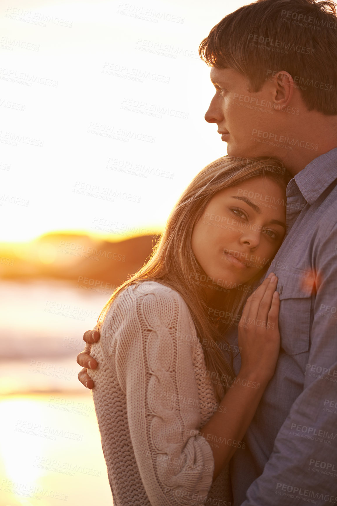 Buy stock photo Couple, portrait and hug by beach at sunset, ocean waves and peace for romance in relationship. People, commitment and security in marriage, embrace and travel on vacation or holiday by mockup space