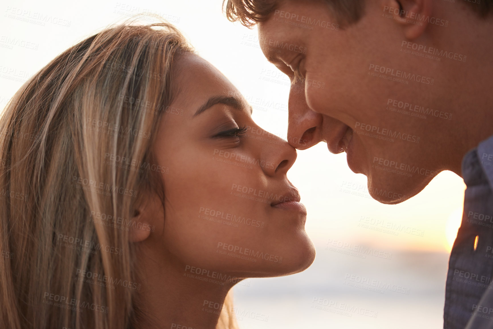 Buy stock photo Nose touch, couple and romantic on beach at sunset, love and commitment in marriage on vacation. Man, woman and care by ocean for bonding together, happy and honeymoon holiday in summer in nature