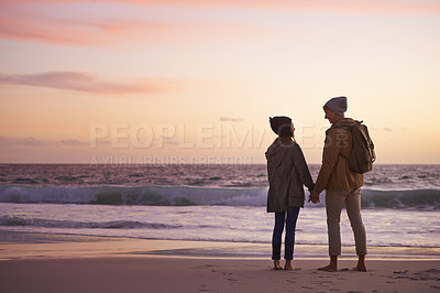 Buy stock photo Couple, holding hands and love at sunset by water, ocean waves and peace for romance in relationship. People, back and security in marriage, sea and travel together on vacation or holiday for date