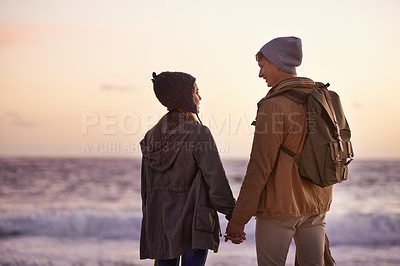 Buy stock photo Couple, holding hands and love at sunset by beach, ocean waves and peace for romance in relationship. People, back and security in marriage, sea and travel together on vacation or holiday for date