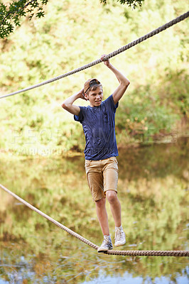 Buy stock photo Forest, camp and boy with balance on rope for exercise, fun challenge and summer vacation in Canada. Teenager, hanging and smile for holiday, enjoyment and adventure course in nature by river
