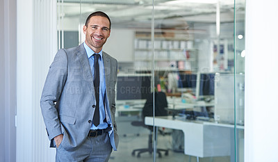 Buy stock photo Shot of a handsome businessman standing in his office