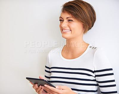 Buy stock photo Shot of a humorous young woman using her digital tablet