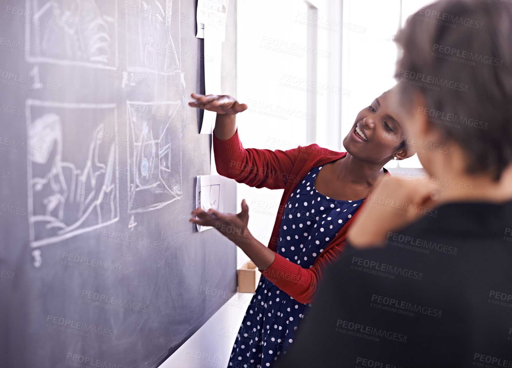 Buy stock photo Shot of two female designers working on a chalkboard in their office