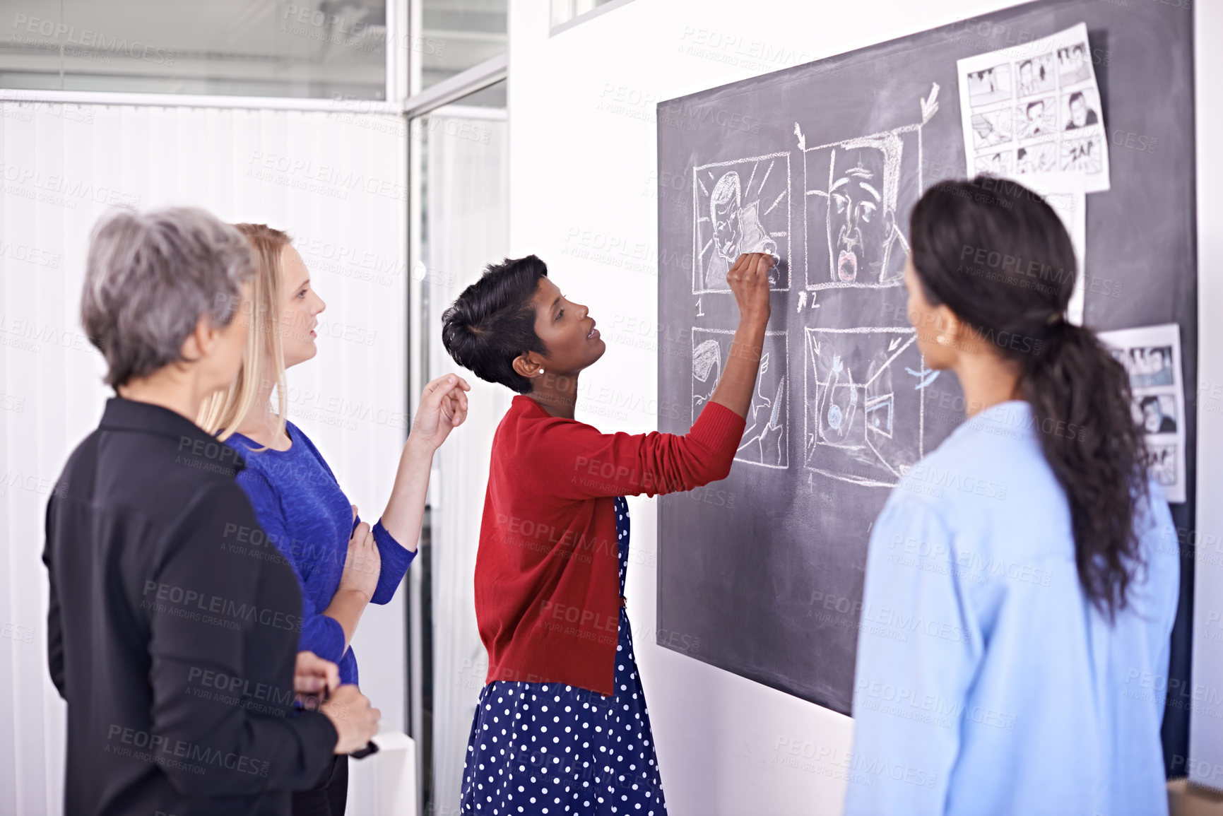 Buy stock photo Shot of a group of female designers working on a chalkboard in their office