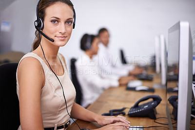Buy stock photo Portrait of an attractive young help desk operator wearing a headset and sitting at her computer