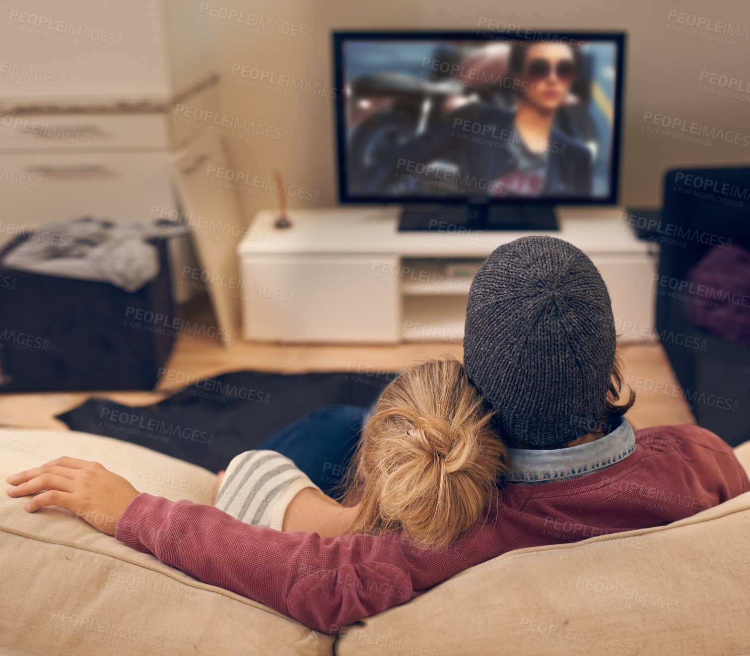 Buy stock photo Rear view shot of a young couple watching TV together