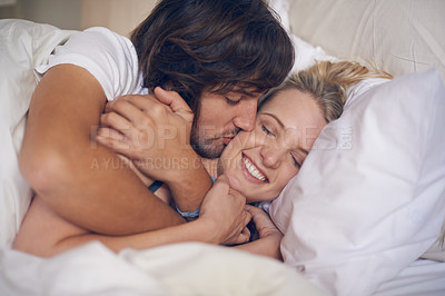 Buy stock photo Cropped shot of a couple showing affection in bed