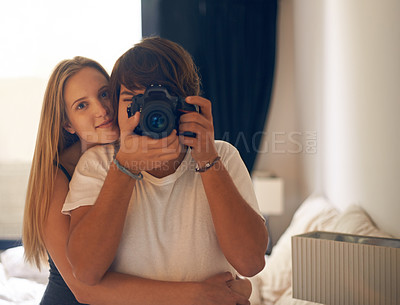 Buy stock photo Camera, photography and couple on a bed with love, care and bonding in their home together. Lens, picture and portrait of people hug in a bedroom with support, security vacation memory in their house