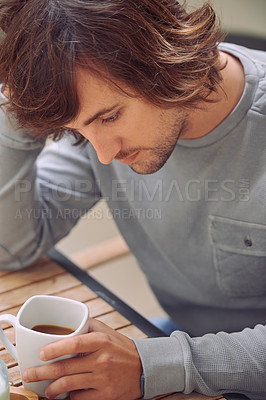 Buy stock photo Shot of a young man looking thoughtful while drinking a coffee