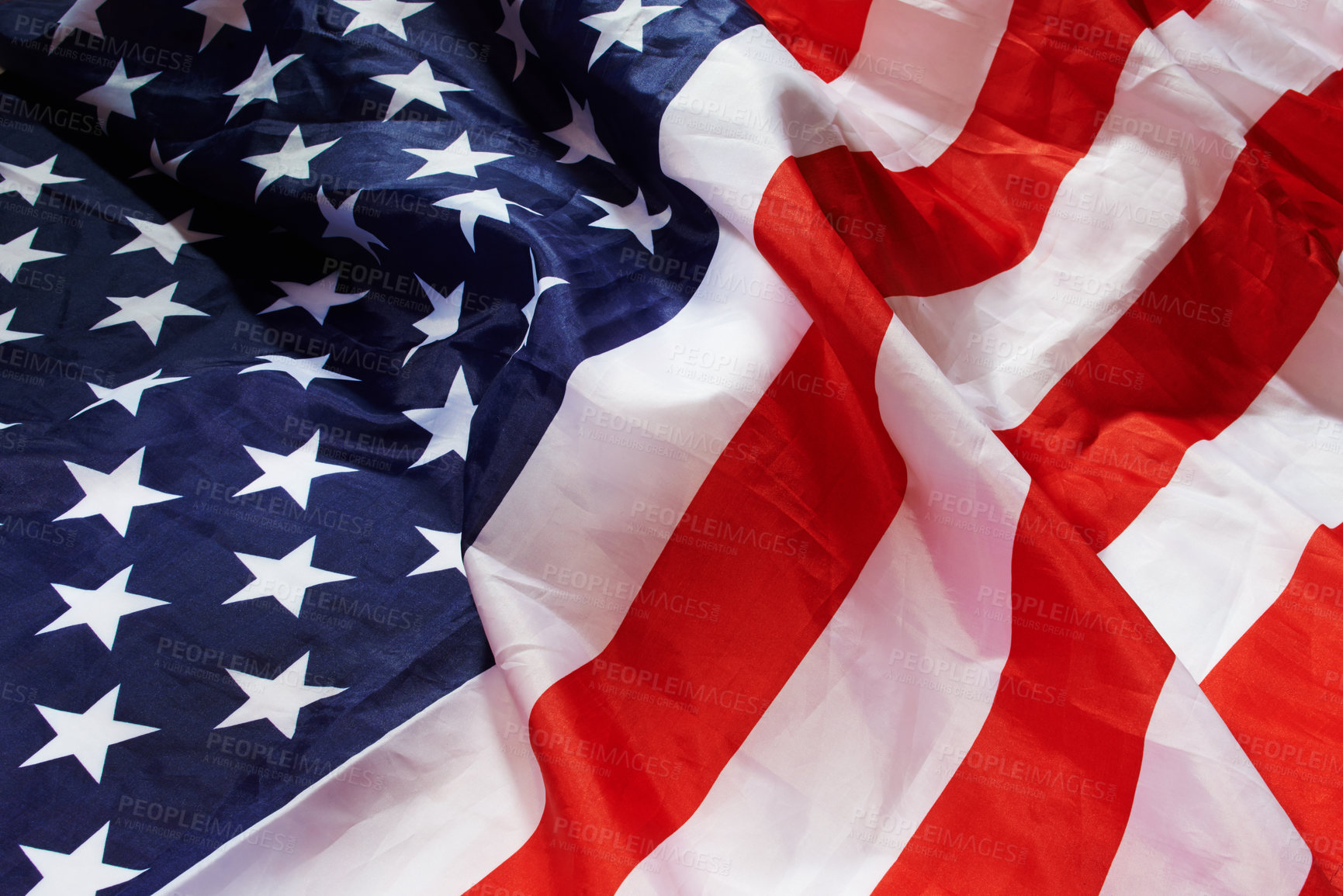 Buy stock photo Closeup of the American flag. Wrinkled fabric of the blue and white stars and red stripes on an American flag. Symbols of freedom and patriotism, celebrating independence day on the fourth of July