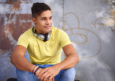 Buy stock photo Smile, thinking and young man at skatepark for skating practice or training for competition. Happy, gen z and face of cool male person sitting on ramp with positive, good and confident attitude.