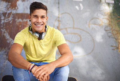 Buy stock photo Gen z, portrait and young man at skatepark for skating practice or training for competition. Happy, smile and face of cool male person sitting on ramp with positive, good and confident attitude.