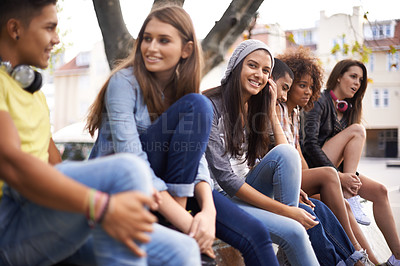 Buy stock photo Happy, portrait and girl with students in city for bonding, talking and sitting together. Smile, diversity and young female teenager with group of gen z friends in conversation in urban town.