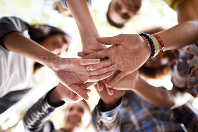 Buy stock photo A group of friends standing in a huddle with their hands piled