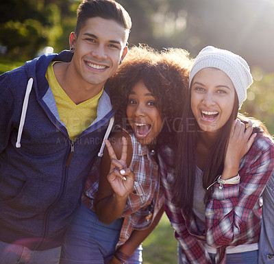 Buy stock photo Portrait, smile and diversity student friends in nature, outdoors or garden with happy expression. Hug, joy and peace sign hand gesture from female person, university and excited learner in school