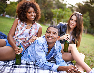 Buy stock photo Portrait of a group of happy young friends having drinks while on a picnic
