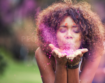 Buy stock photo Shot of an attractive young woman blowing purple paint powder at the camera