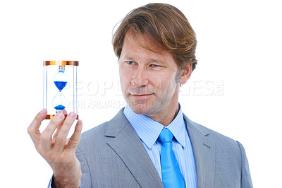 Buy stock photo Businessman, checking and time management with hour glass for schedule or limit on a white studio background. Young man or employee looking at sand for minutes, seconds or deadline on mockup space