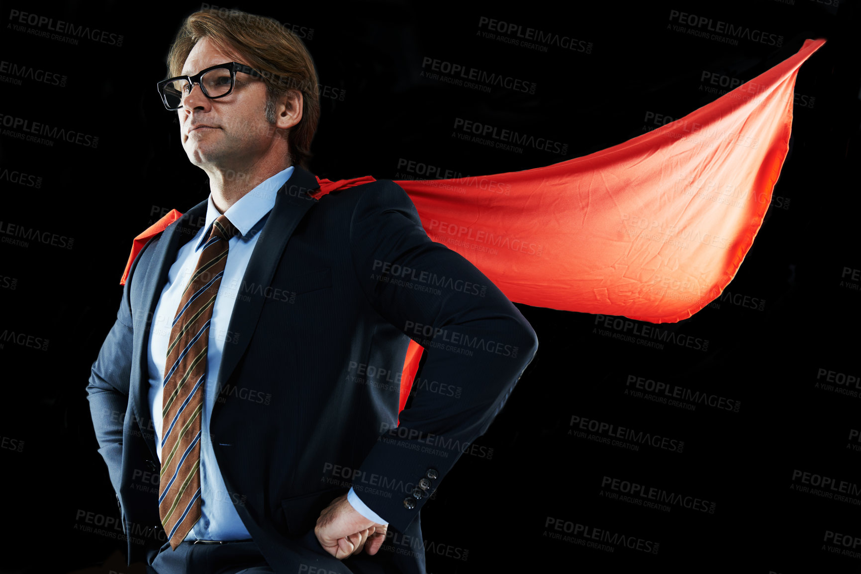 Buy stock photo Shot of a businessman with his hands on his hips wearing a red cape