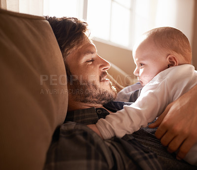 Buy stock photo Smile, father and bonding with baby on sofa in home living room or playing together. Happiness, care and dad cuddle with infant, newborn or child on couch in lounge, having fun or enjoying relax time