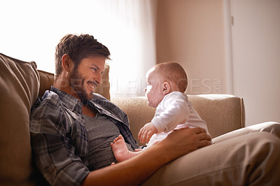 Buy stock photo Smile, father and baby sitting on lap on sofa in home living room, bonding or playing together. Happiness, care and dad with newborn child on couch in lounge, having fun and enjoying relax time.