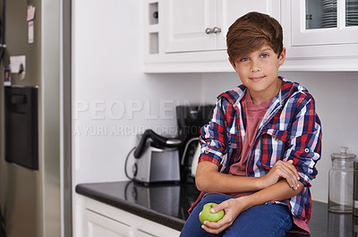 Buy stock photo Portrait, apple and teen boy in kitchen of home, eating organic food for diet, health or nutrition. Children, fruit and wellness with confident young kid holding fresh green produce for growth