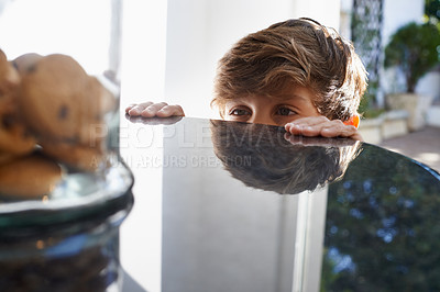 Buy stock photo A young boy eyeing the cookie jar on top of the kitchen counter